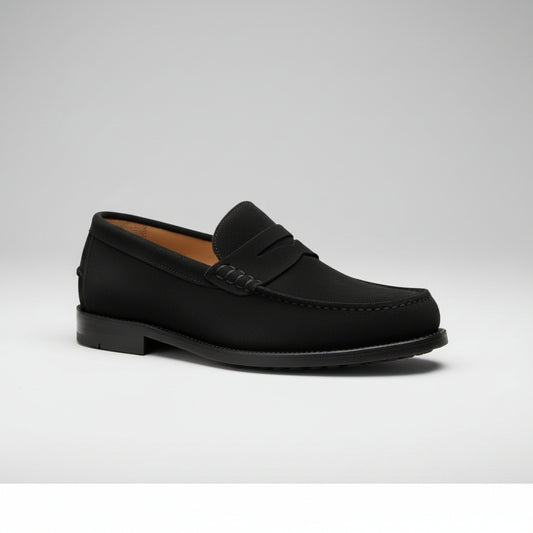 Black loafers worn by a person with a neutral background
